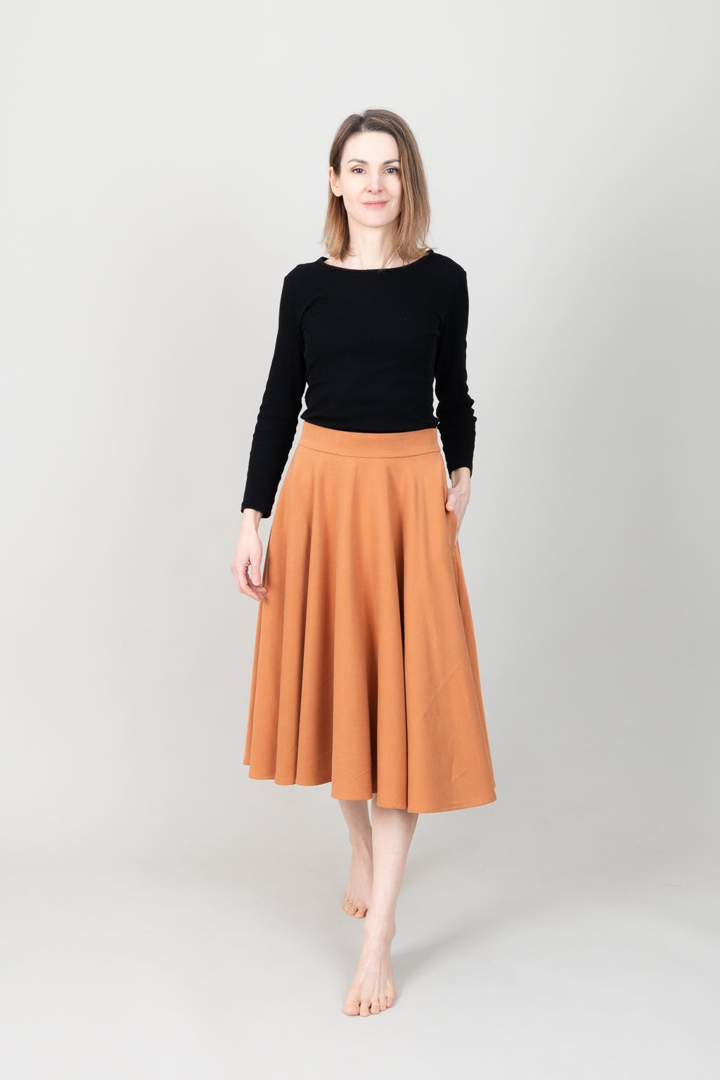 Frau in Tencel-Tellerrock Drehrock in der Farbe Karamell mit Taschen; Urheber: Mini & Eve